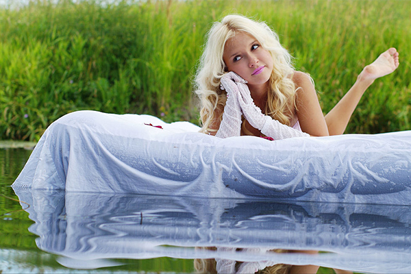 Фото красивой девушки, плывущей по реке на надувном матрасе